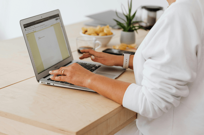 Healthcare professional working on digital documentation at a laptop.