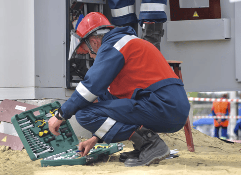 A man in construction attire choosing tools from a toolbox