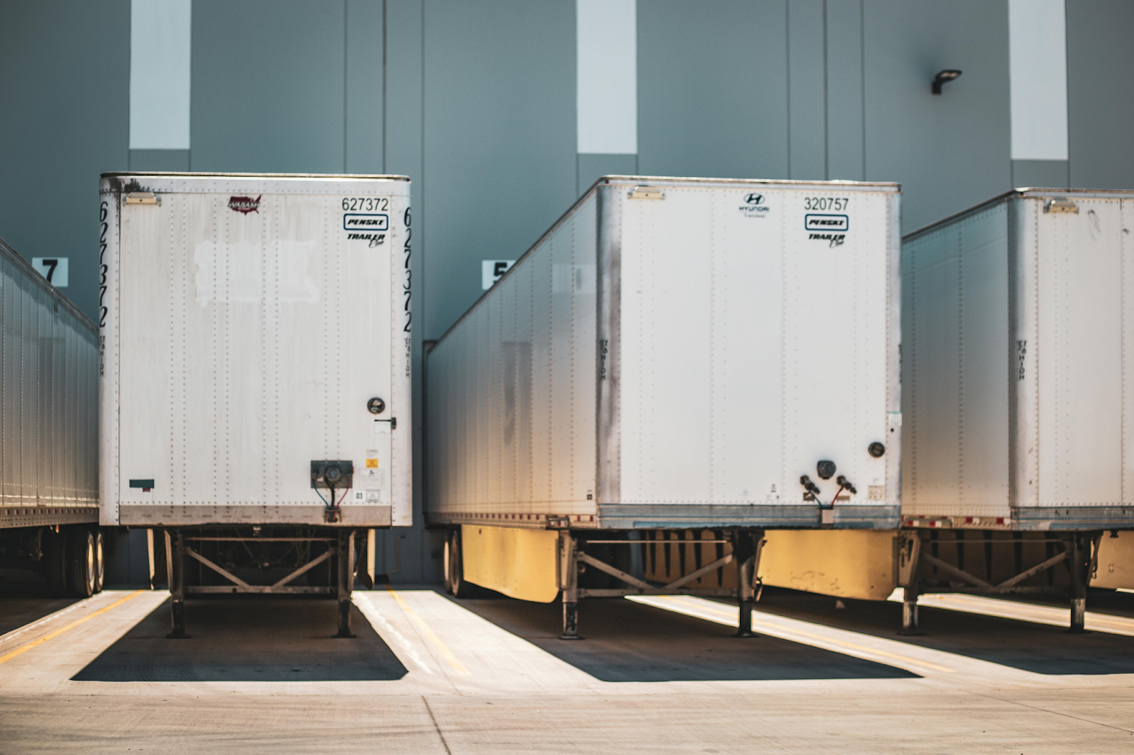 Semi-truck trailers are parked at a warehouse loading dock