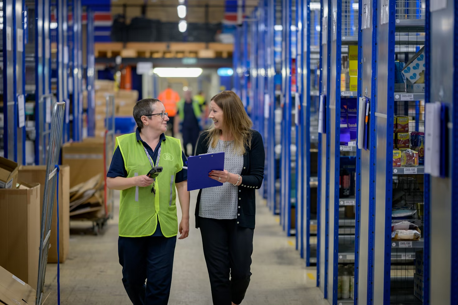Two warehouse workers are conducting a Gemba walk