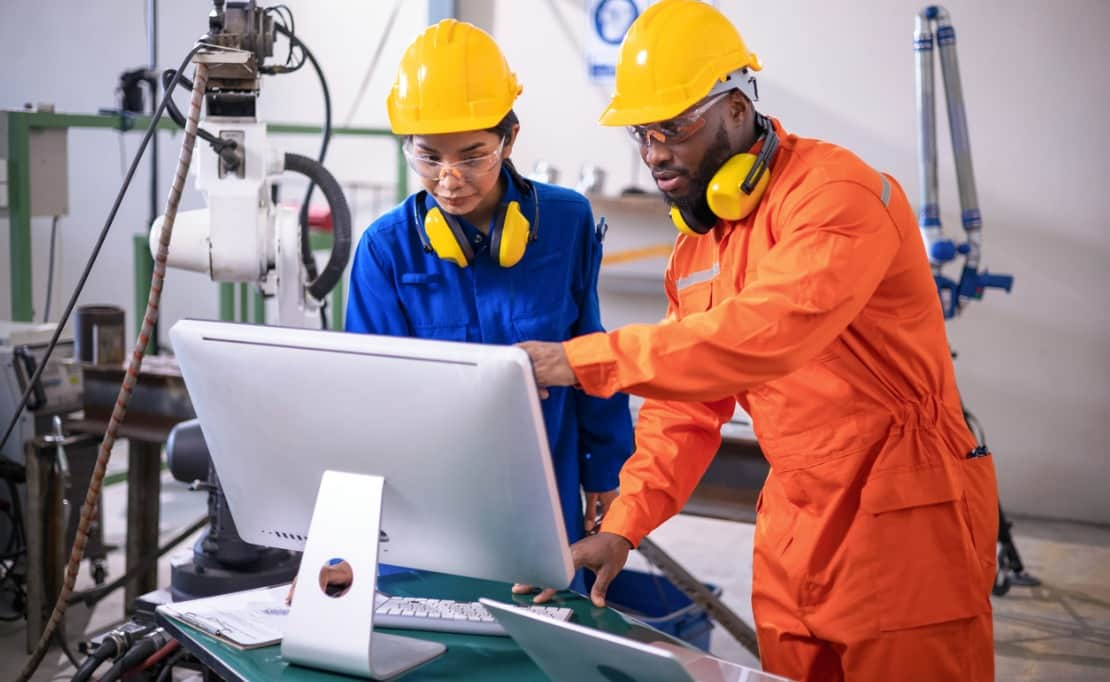Manufacturing personnel taking a look at an inventory monitor screen